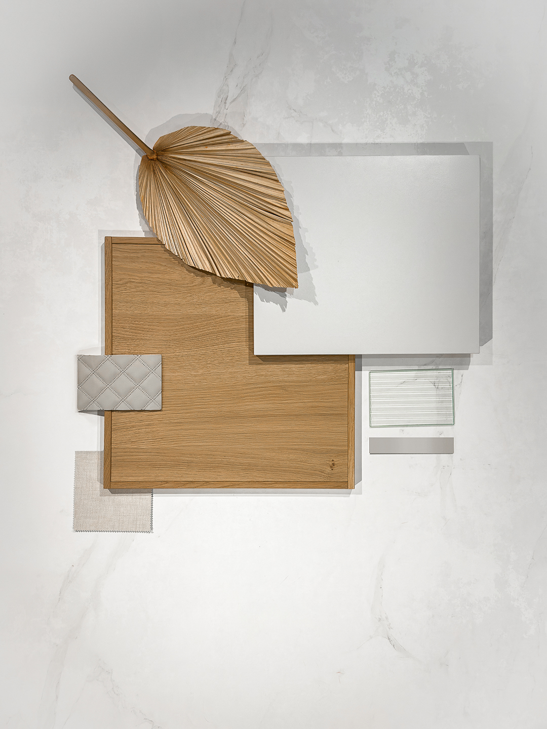 Planche tendance composée de bois, laqué mat, verre strié et tissu lin illustrant la palette naturelle du style Japandi.