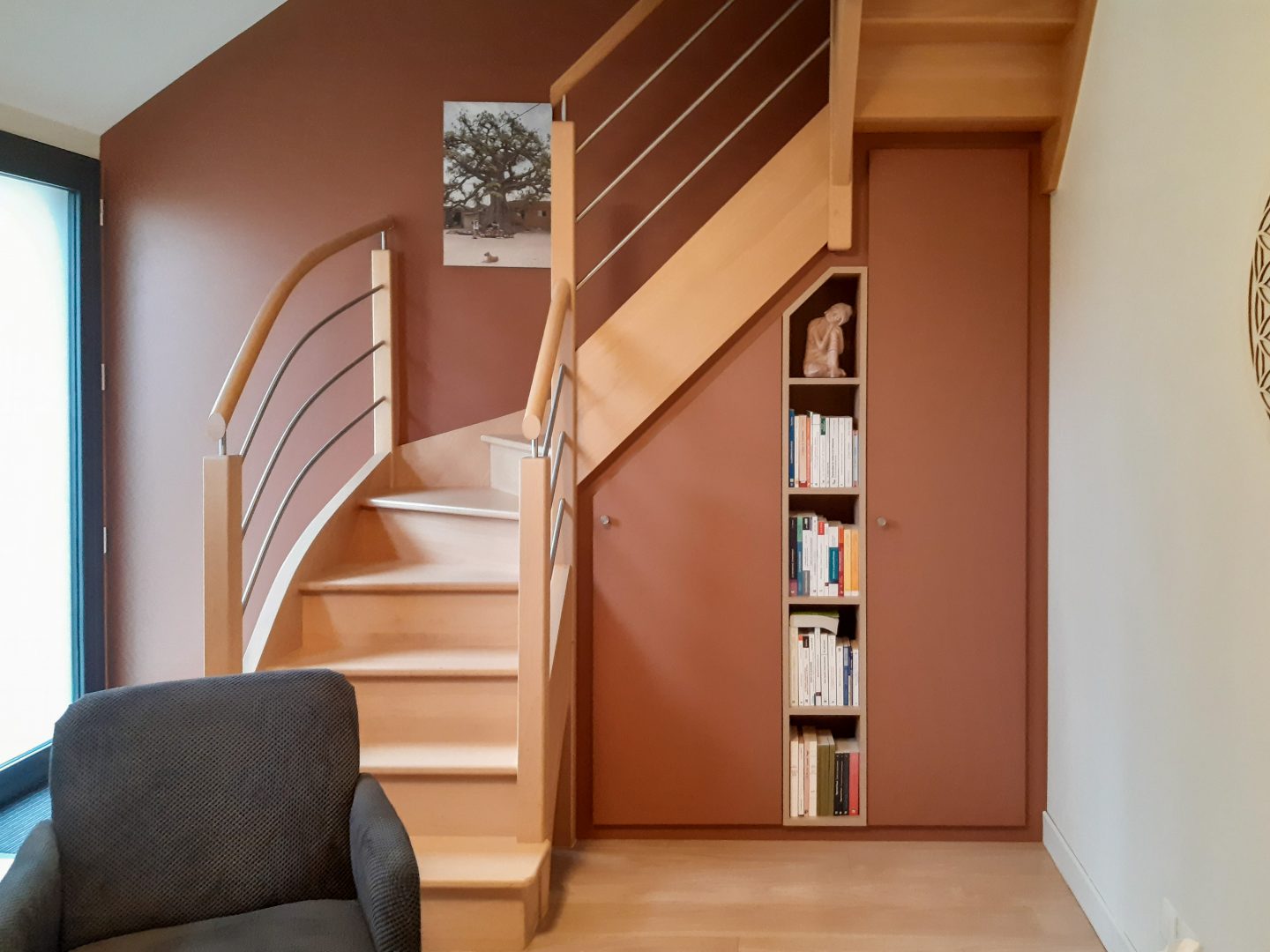 Transformation d'un espace vide de sous-escalier en rangement et petite bibliothèque fonctionnelle - réalisation Intérieurs Privés Rennes