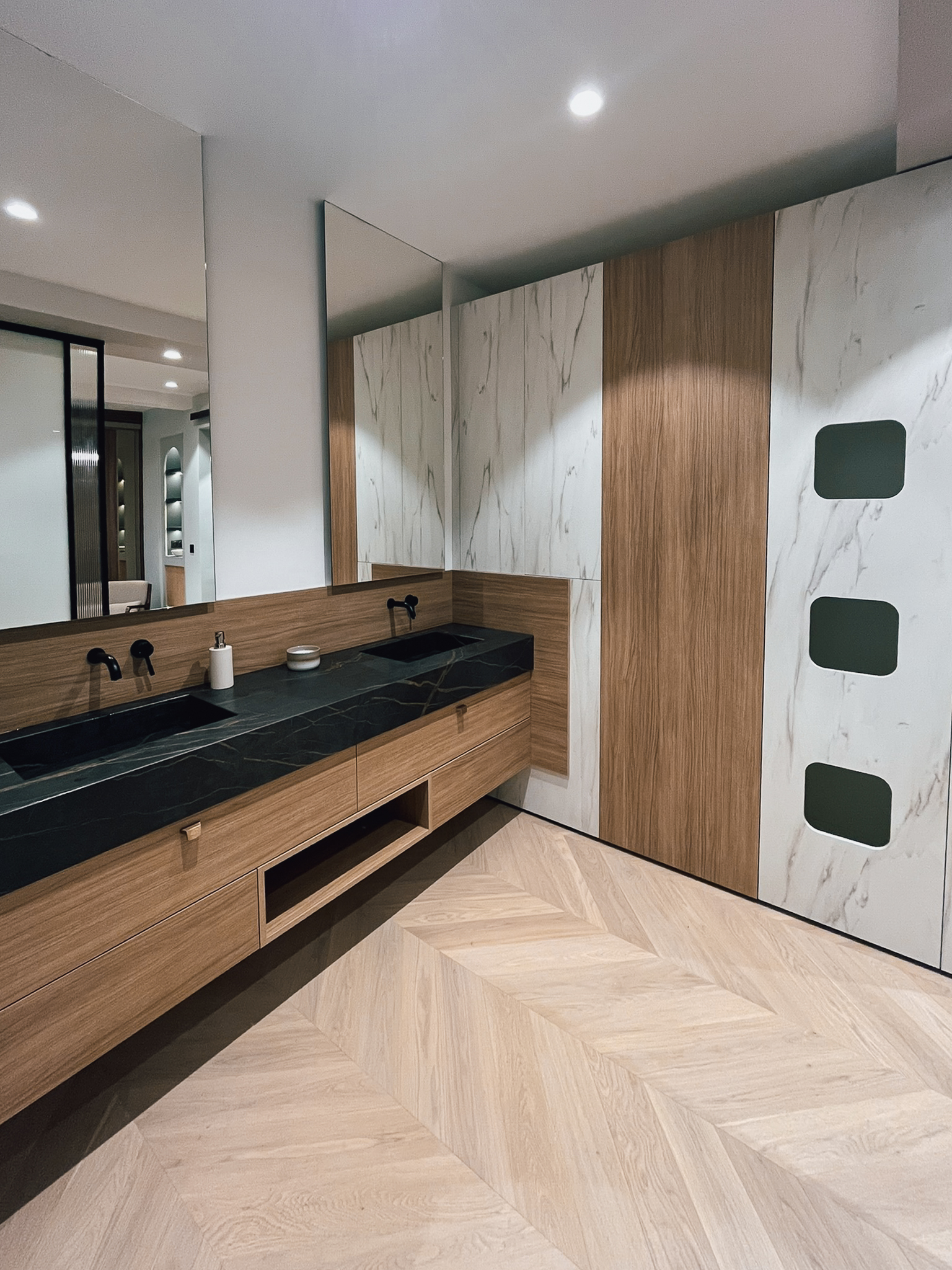 Vue d’ensemble d’un aménagement de salle de bain sur mesure chez Intérieurs Privés Paris 6, associant meuble vasque, rangements pleine hauteur et finitions bois et minérales. Une illustration du savoir-faire en agencement intérieur personnalisé.