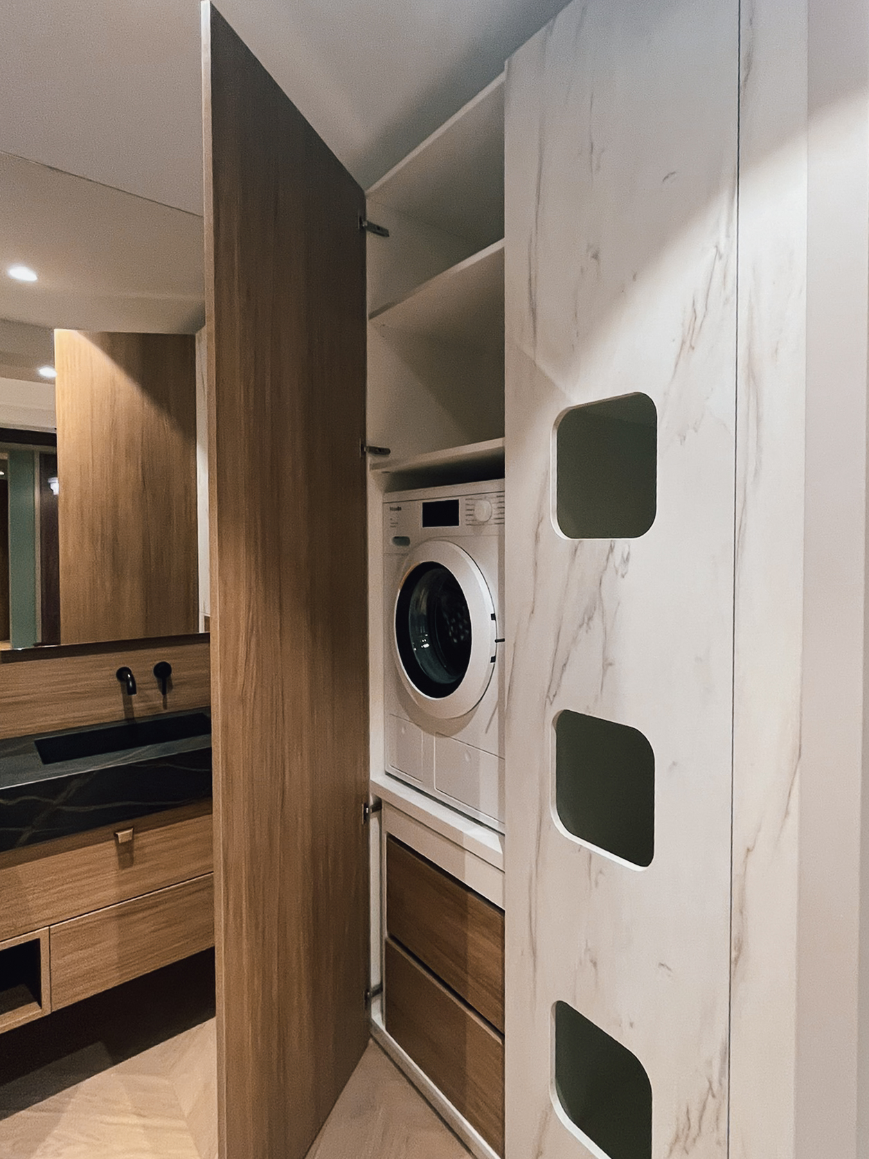 Colonne buanderie sur mesure exposée chez Intérieurs Privés Paris 6, intégrant lave-linge, rangements fermés et étagères hautes. Un aménagement discret, pensé pour optimiser l’espace tout en assurant une continuité esthétique.