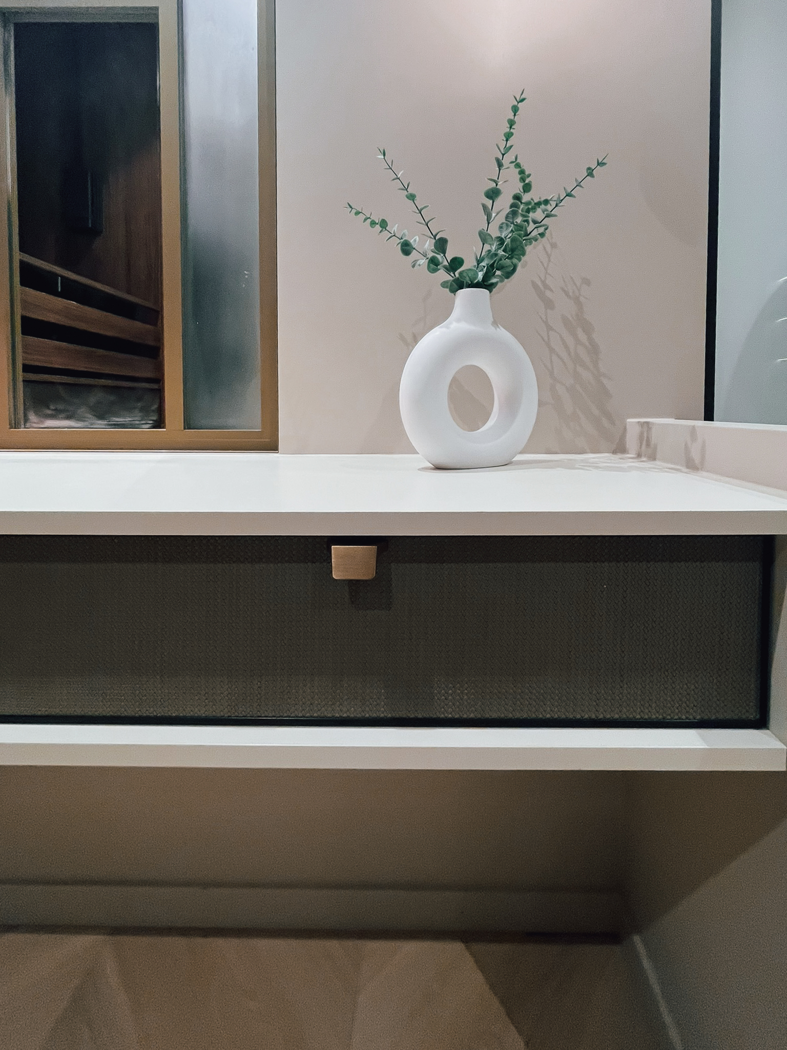 Gros plan sur un tiroir sur mesure avec façade texturée et bouton discret, intégré à un plan de travail aux lignes nettes. Une illustration du niveau de finition proposé par Intérieurs Privés Paris 6.