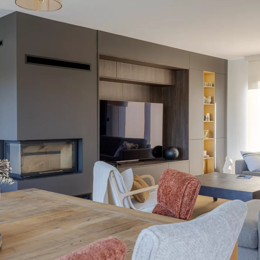 Salon contemporain avec meuble TV sur mesure, cheminée intégrée, rangements muraux et niche décorative éclairée.