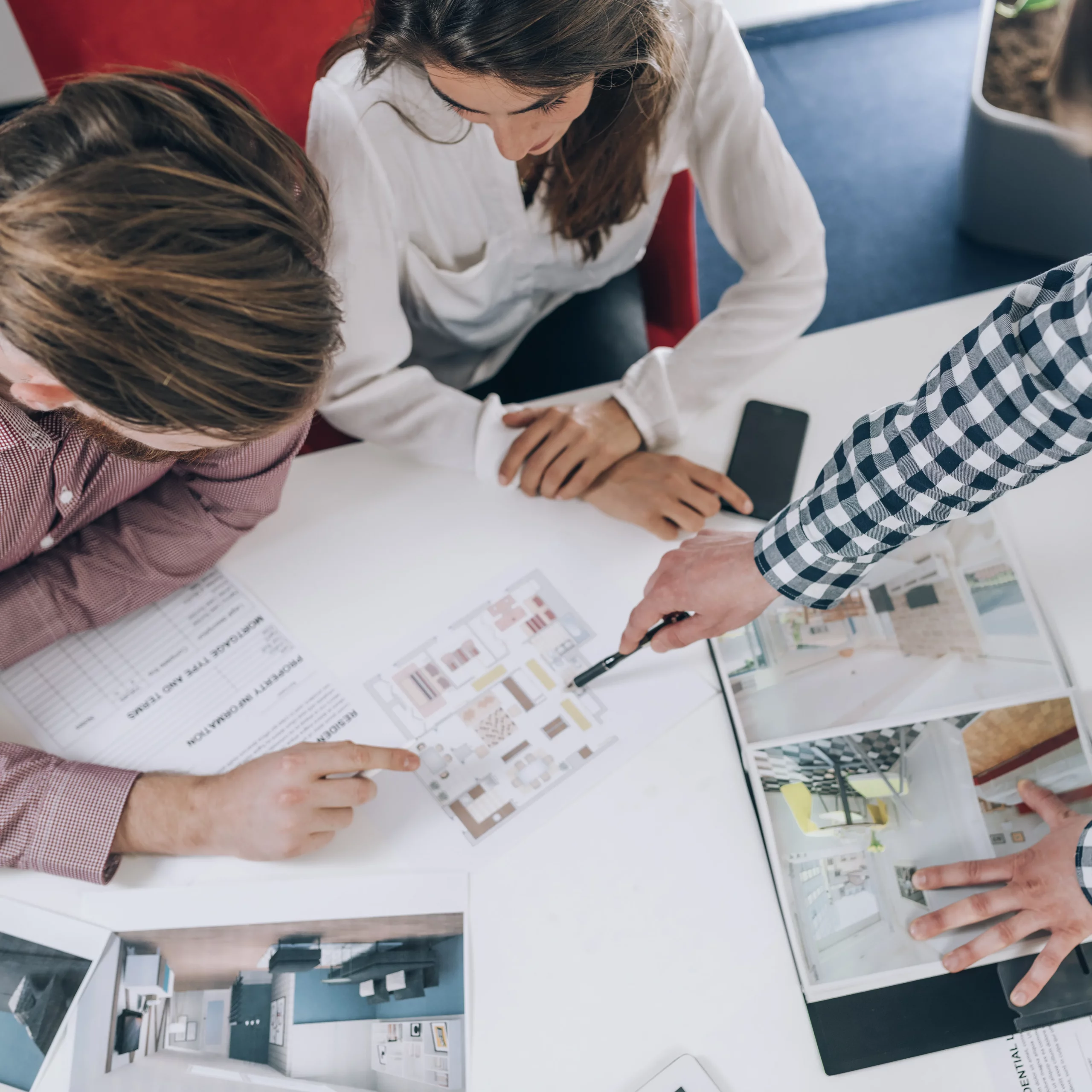 Échange entre clients et concepteur autour de plans et visuels 3D pour préparer un projet d’aménagement sur-mesure.