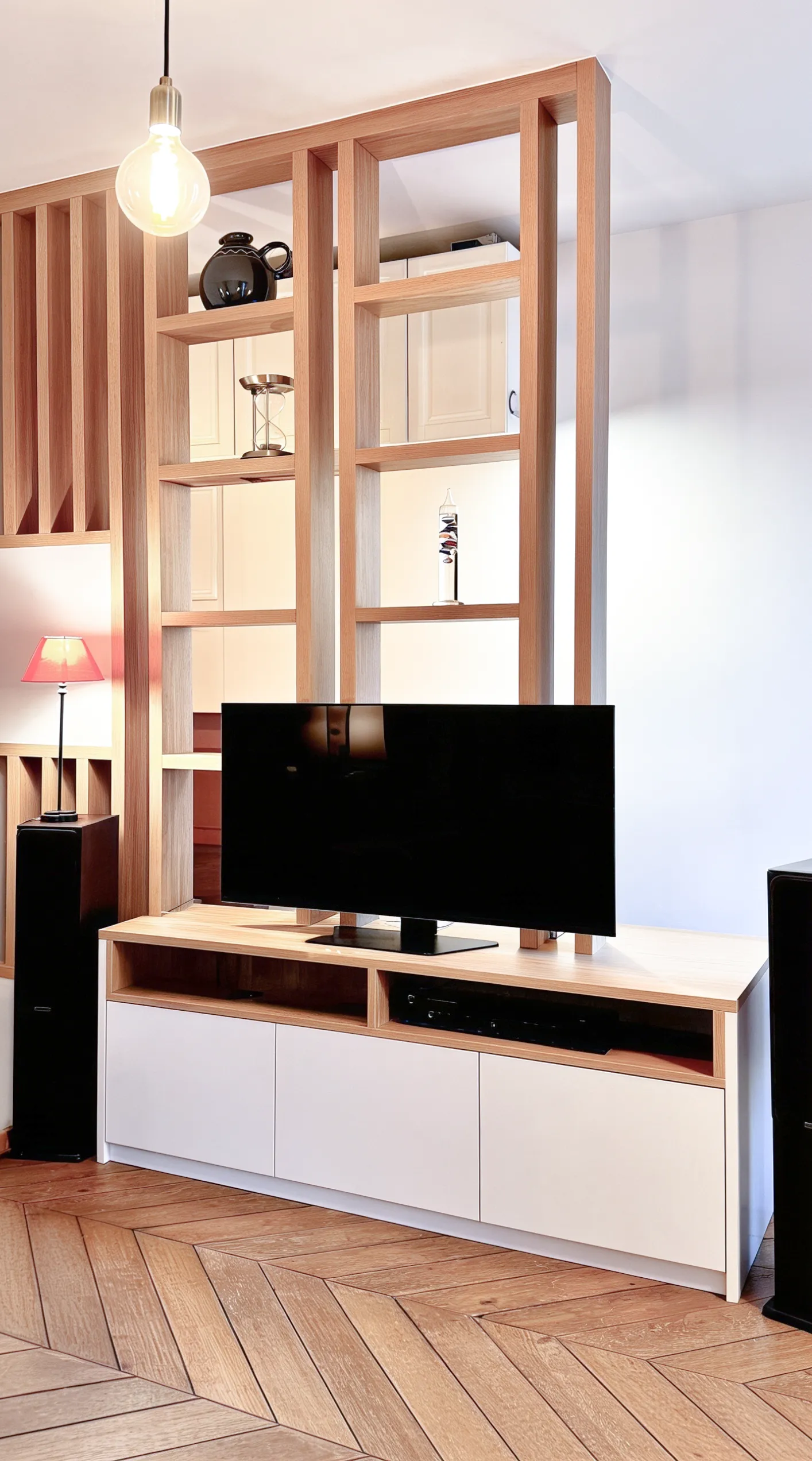 Vue complète d’un meuble TV sur-mesure avec claustra bois, rangements bas et séparation ajourée.