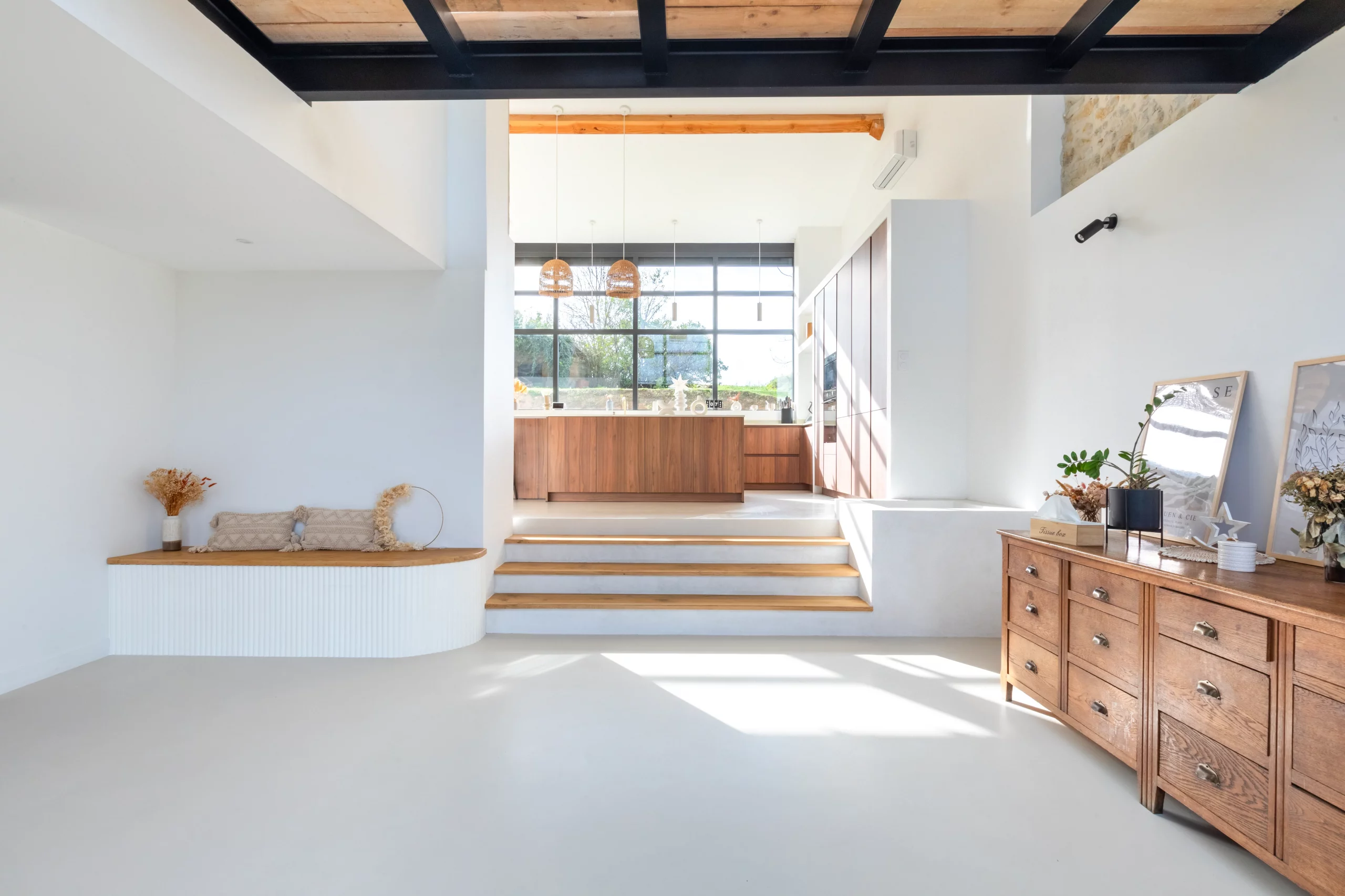 Grande pièce de vie avec table de repas, escalier contemporain, cuisine ouverte et baies vitrées toute hauteur