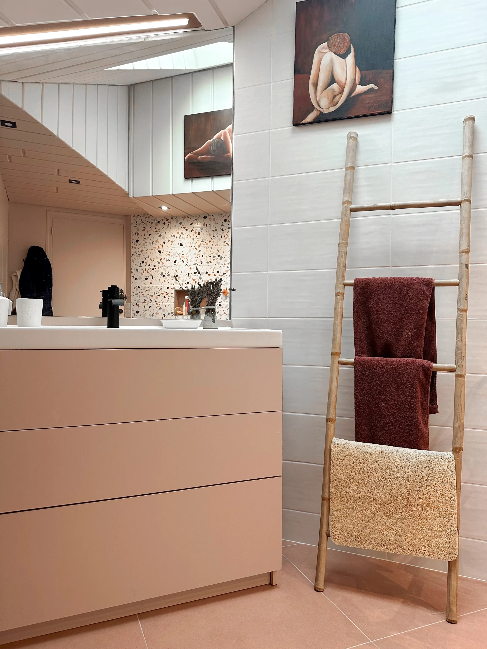 Salle de bain avec meuble vasque sur-mesure, miroir, rangements intégrés et espace buanderie conçu pour optimiser la pièce.