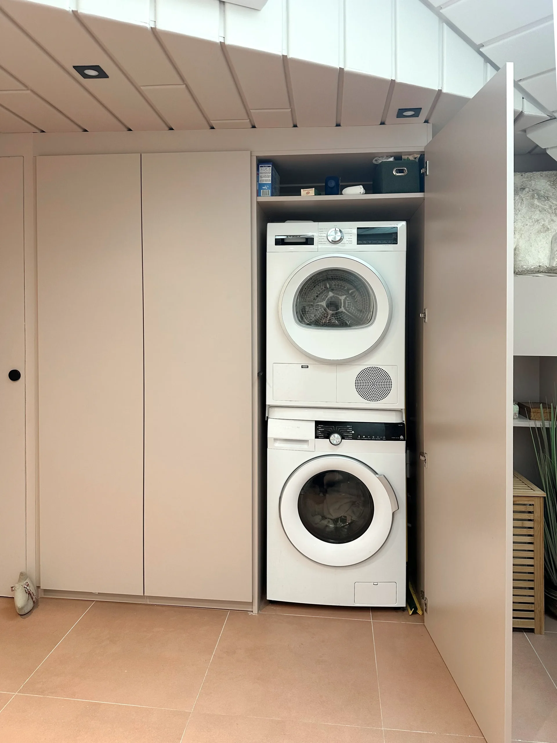 Lave-linge et sèche-linge superposés et dissimulés dans un meuble sur-mesure au sein de la salle de bain à Lannion.