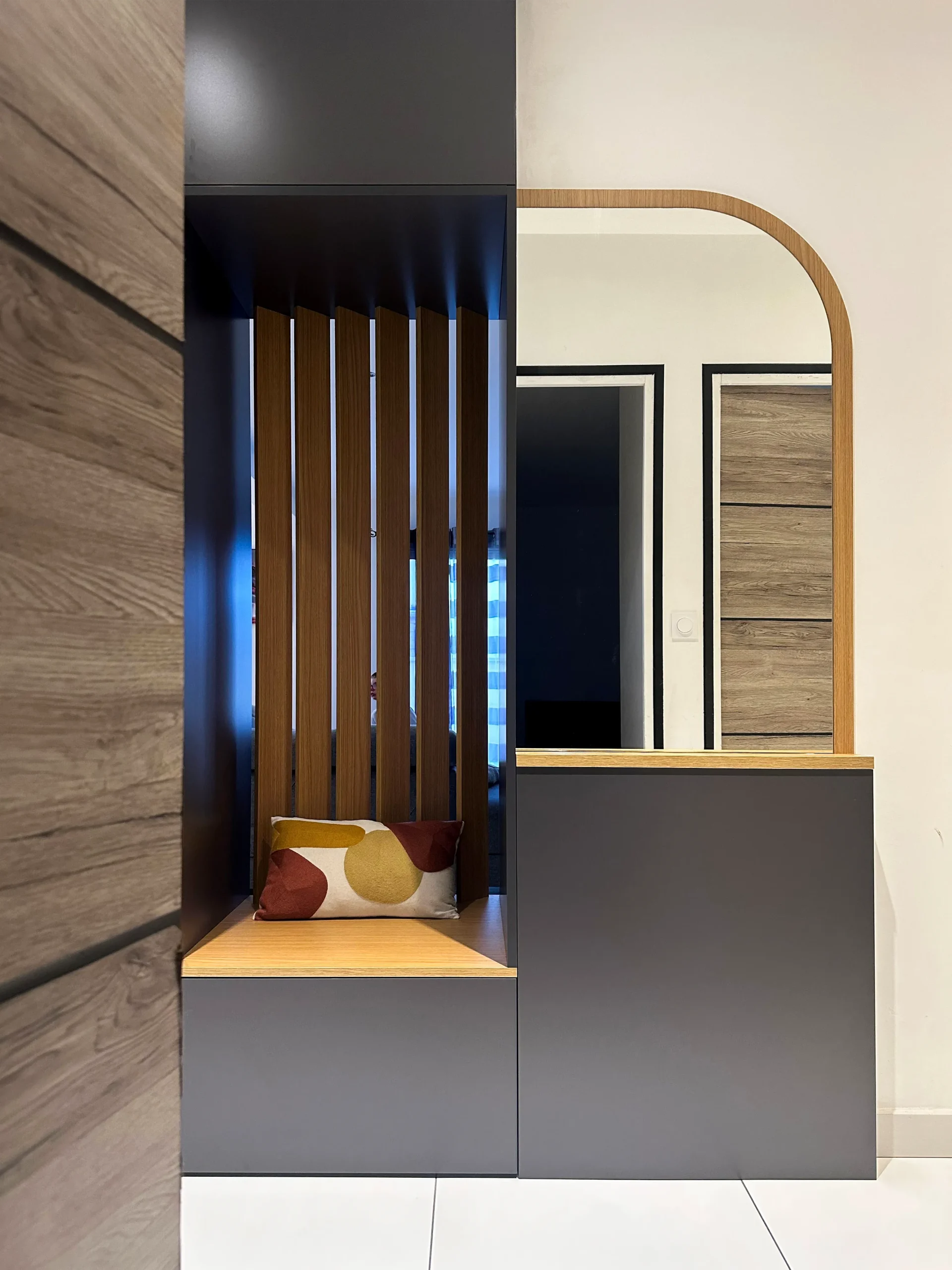 Meuble d’entrée sur-mesure bi-face associant rangements fermés, assise, claustra en bois et miroir à Ploubezre.